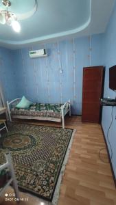 een kamer met een bed en een tapijt in een kamer bij Umid Hostel in Bukhara
