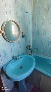 a bathroom with a blue sink and a mirror at Umid Hostel in Bukhara