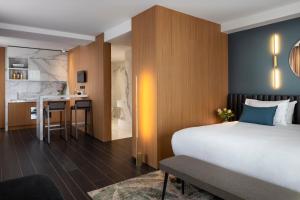 a hotel room with a large bed and a kitchen at Howard sur Seine - Asnieres Paris La Defense in Asnières-sur-Seine