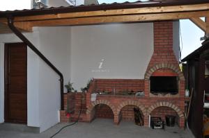 uma lareira de tijolos com um forno de tijolos numa casa em Vila ALBA AREAL em Costinesti