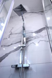 Una ducha en una habitación con paredes de mármol blanco. en Dreamich - Scavi Romani, en Desenzano del Garda