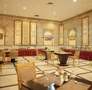 a restaurant with tables and chairs in a room at Crown Palace Hotel in Ajman 