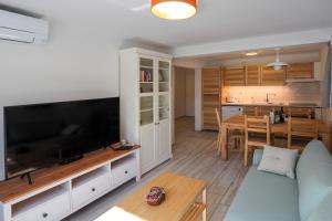 uma sala de estar com uma grande televisão de ecrã plano em Apartments Erman em Bled
