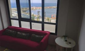 a living room with a red couch and a large window at Pisos El Puerto in Santa Cruz de la Palma