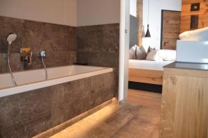 a bathroom with a bath tub next to a bed at Hotel Cores in Fiss