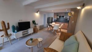 salon z kanapą i stołem oraz kuchnia w obiekcie L Arancio - Centre village - Piscine - 4 pers w mieście Bessan