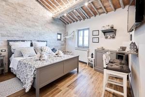 Un dormitorio con una cama y una pared de ladrillo. en La Casina di Aldo, en Montepulciano