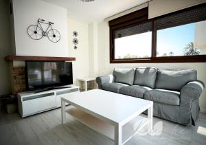 a living room with a couch and a tv and a table at PUSHE Village Playa Granada Beach & Golf 3 in Motril