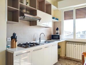 cocina blanca con fregadero y fogones en Casa Bignardi - Affitti Brevi Italia, en Módena