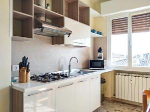 a white kitchen with a sink and a stove at Casa Bignardi - Affitti Brevi Italia in Modena