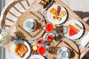 a table with plates of breakfast food on it at Sollaris Ecopousada in Japaratinga
