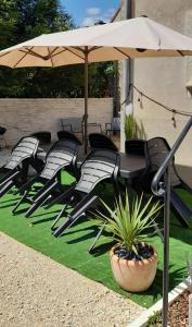 a group of chairs sitting under an umbrella at Gîte et Spa 21 in Savigny-le-Sec