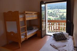 - une chambre avec des lits superposés et une grande fenêtre dans l'établissement ULVF Les Essertets, à Praz-sur-Arly