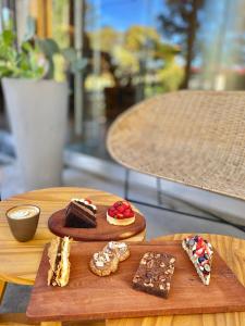 a group of desserts on a wooden table at ÑU Posta Urbana Hotel Boutique in Córdoba