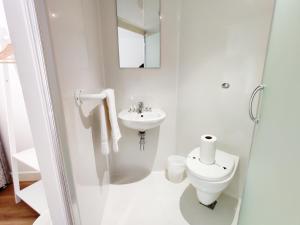 La salle de bains blanche est pourvue de toilettes et d'un lavabo. dans l'établissement Accommodation Bradford, à Bradford