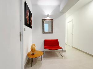a red chair and a table in a hallway at Hostal Las Palmas in Carboneras +25 photos