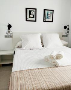Hostal Las Palmas في كاربونيراس: غرفة نوم عليها سرير وفوط