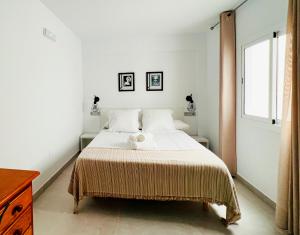a white bedroom with a bed with a blanket at Hostal Las Palmas in Carboneras