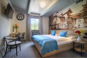 a bedroom with a large bed with a painting on the wall at Hotel Start in Špindlerův Mlýn