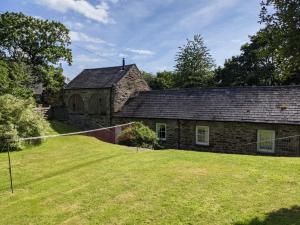 an old stone house with a yard in front of it at Yr Hen Feudy in Barmouth