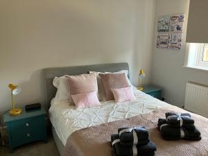 um quarto com uma cama com almofadas cor-de-rosa em Beautiful 4 Double Bedroom House in Poole with Hot tub, near Sandbanks em Poole