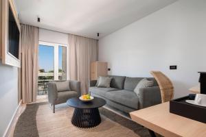 a living room with a couch and a table at Beach Bay Hvar Hotel in Hvar