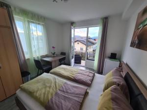 una camera da letto con due letti, una scrivania e una finestra di Orchidea2 a Finkenstein am Faaker See