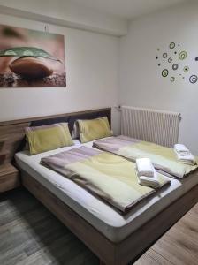 two beds in a room with a phone on top at Orchidea2 in Finkenstein