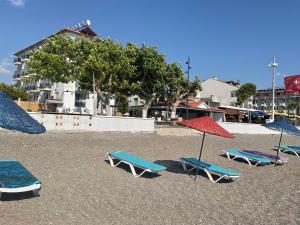 eine Gruppe von Stühlen und Sonnenschirmen am Strand in der Unterkunft MIA CASA HOTEL in Fethiye