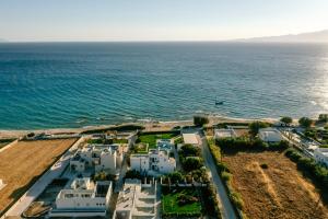 an aerial view of a white building by the ocean at Blue Myth Studios in Kastraki