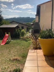 un patio con un parque infantil con un tobogán rojo en L'Azilienne, jolie maison à 2 pas du village - L'Azilienne, pretty house 2 steps from village, en Le Mas-dʼAzil