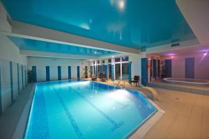 a large swimming pool in a building with a tub at Hotel Kameralny in Kielce