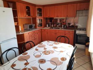 a kitchen with a table and chairs and a refrigerator at Farkas Szállás in Báránd