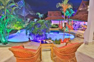 查汶的住宿－蘇梅島小花園度假酒店，一个带桌椅的游泳池的度假酒店