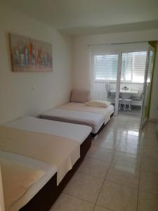 a room with two beds and a table with a table at Mihaela studio apartmans 150m near the beach in Kaštela
