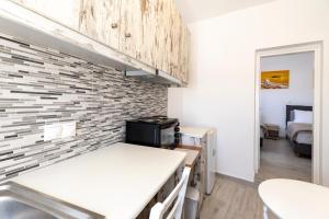 a kitchen with a white counter and a brick wall at Villa Ostrich in Fira