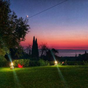 a yard with two lights in the grass at sunset at Artolithia Apartments in Rizá