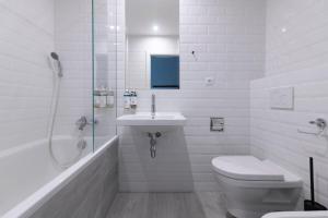 a bathroom with a toilet and a sink and a shower at Numa Prague Root in Prague