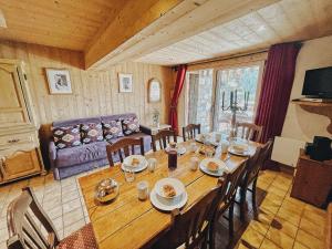 a dining room with a large wooden table with chairs at Le Flocon in Champagny-en-Vanoise