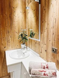 La salle de bains est pourvue d'un lavabo blanc et d'un miroir. dans l'établissement Le Flocon, à Champagny-en-Vanoise