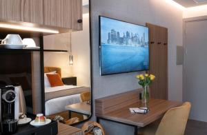 Habitación de hotel con cama y escritorio con TV. en 3T Boutique Hotel, en Ivrea