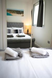 a bedroom with two beds in front of a mirror at Sea, Stay and Relax Away - Stunning, Modern, Home from Home in Newquay