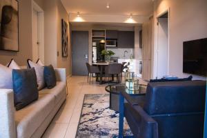 a living room with a couch and a table at The Menlyn Main Residents Trilogy in Pretoria