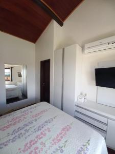 a bedroom with a large bed and a mirror at Flat Winterville Aconchegante próximo as piscinas in Gravatá
