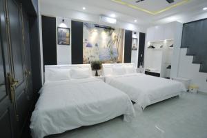 a bedroom with two beds with white sheets at CHIENHOA HOMESTAY in Danang