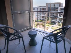 a balcony with two chairs and a table and a window at The Menlyn Main Residents Trilogy in Pretoria