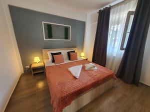1 dormitorio con 1 cama con manta roja y ventana en Apartment Villa, en Bucarest