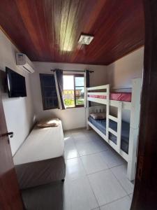 a small room with two bunk beds and a window at Flat Winterville Aconchegante próximo as piscinas in Gravatá