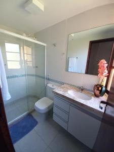 a bathroom with a toilet and a sink and a shower at Flat Winterville Aconchegante próximo as piscinas in Gravatá