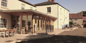 a large white building with a table and chairs at The Drayton Crown in Langport